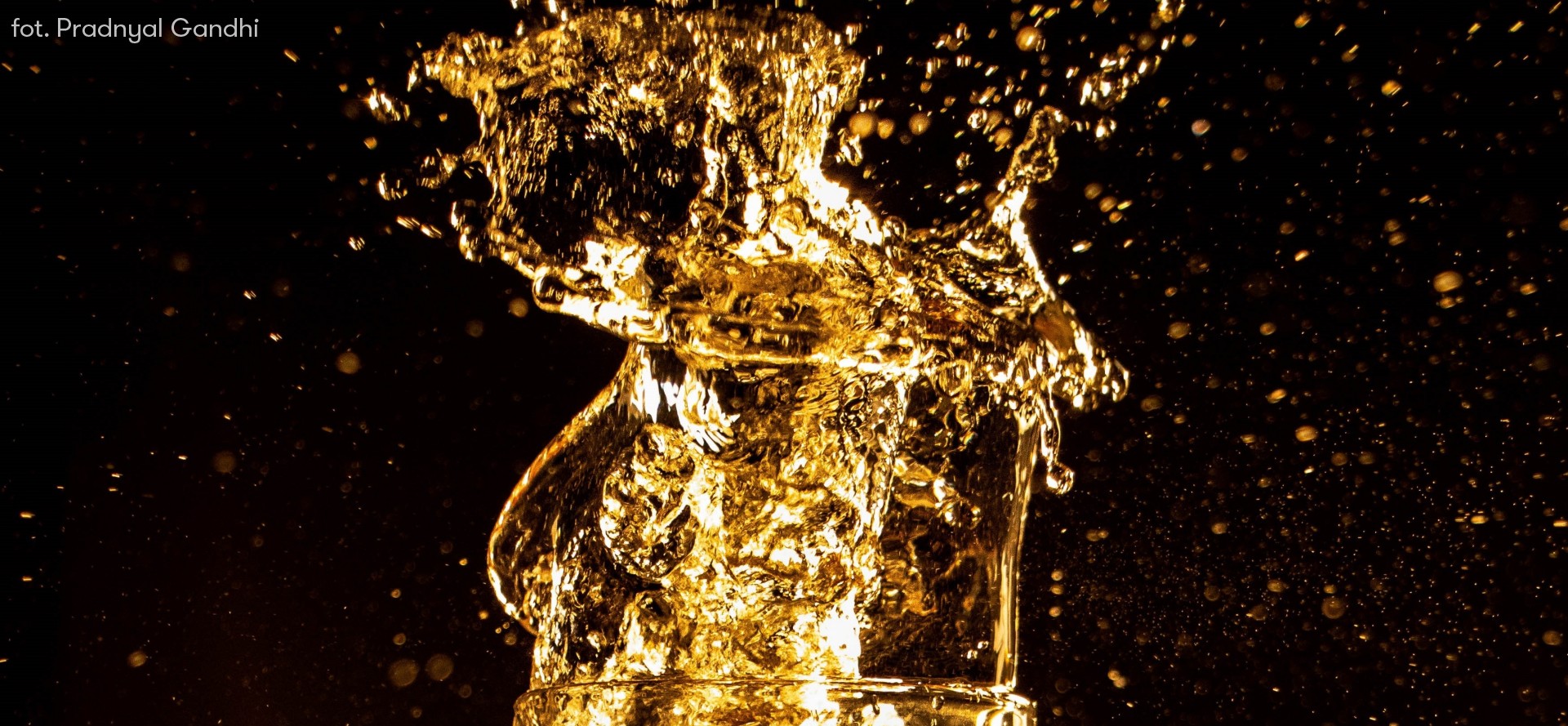 Artystyczne zdjęcie piwa w złotym kolorze wychlapującego się z kufla